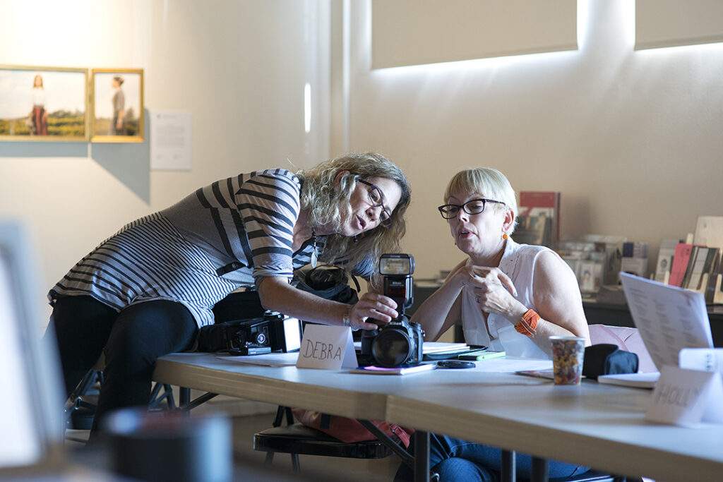 LACP instructor Julia Dean teachiong a student how to use on-camera flash