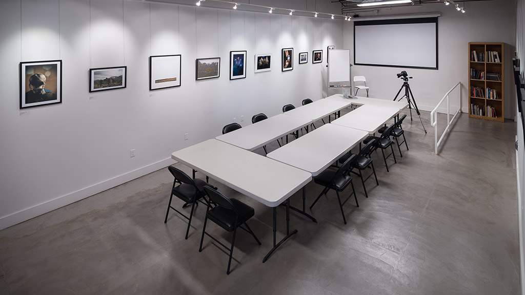 One of LACP's conference spaces with tables, chairs, and projetion screen